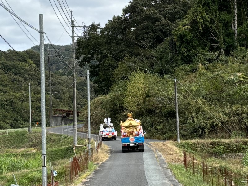 山道を走るお神輿を乗せたトラック