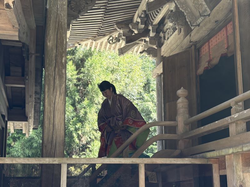 本殿から拝殿へと移動する女性宮司