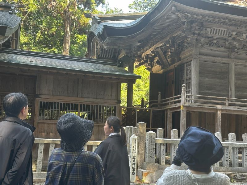本殿を案内する宮司