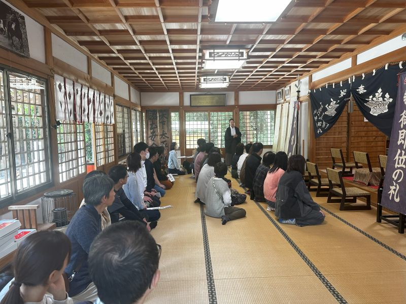 拝殿で宮司の説明を聞く参加者