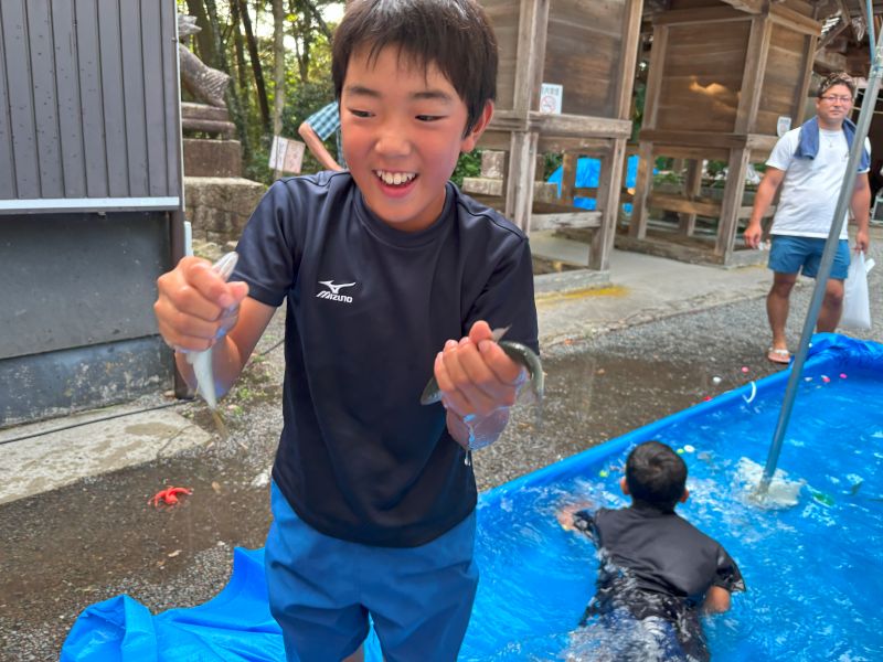 2尾の鮎を同時に捕まえた男の子