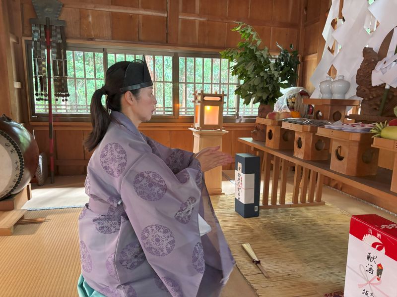 祈りを捧げる女性宮司
