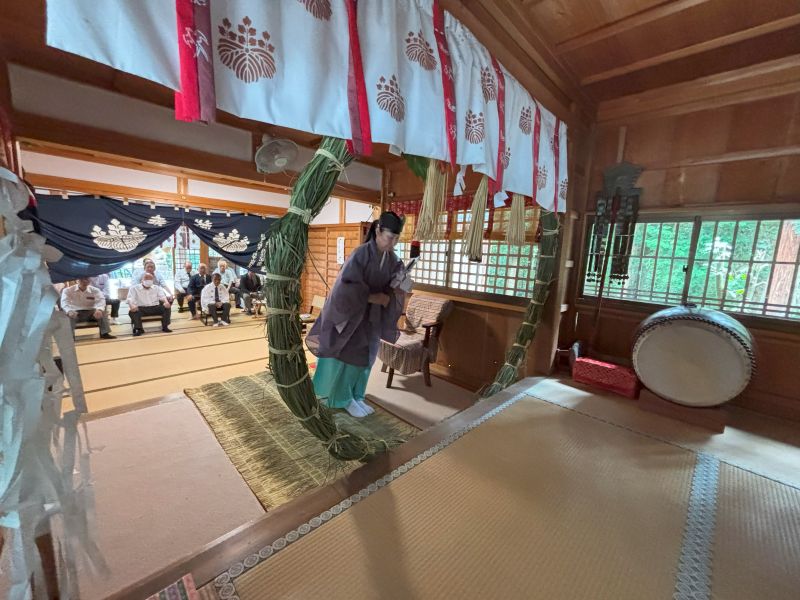 茅の輪をくぐる女性宮司