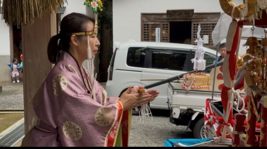 お神輿巡幸前に祈りを捧げる女性宮司