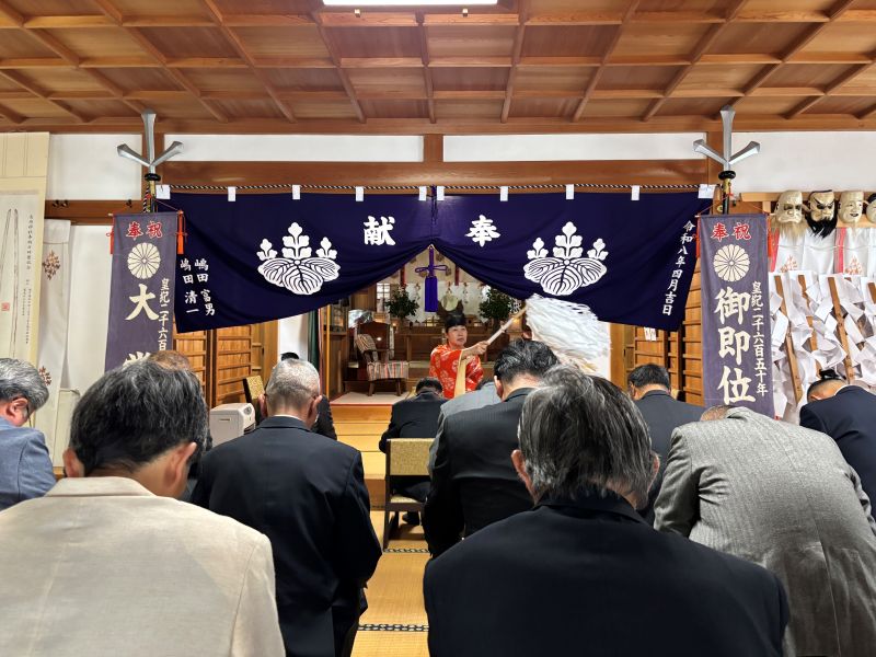 春祭りで参列者にお清めをする女性宮司