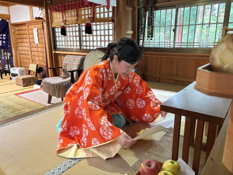 春祭りで祈祷を捧げる女性宮司