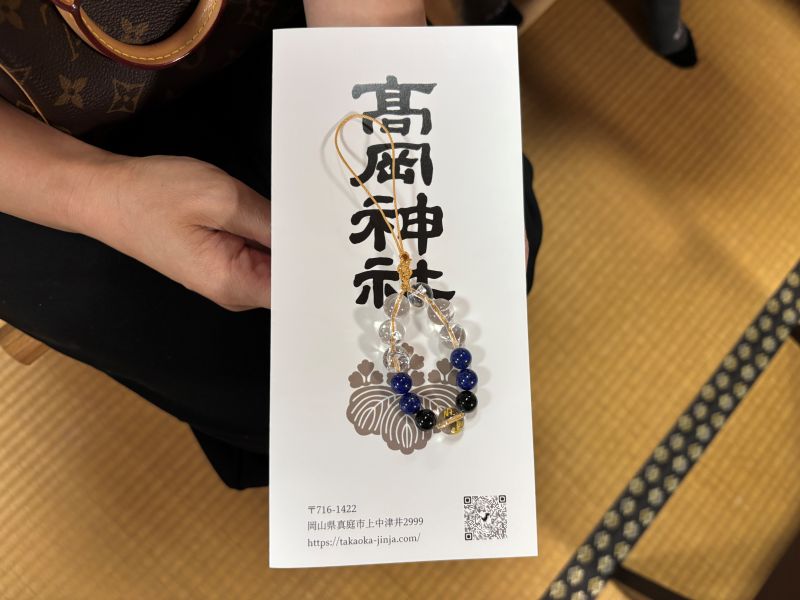 神社のパンフレットの上に置かれた御守りチャーム