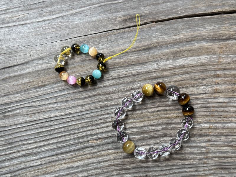 床の上に置かれた御守りチャームとブレスレット