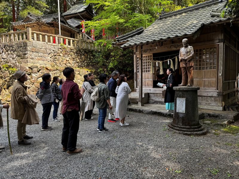 建勲神社の説明をする女性宮司