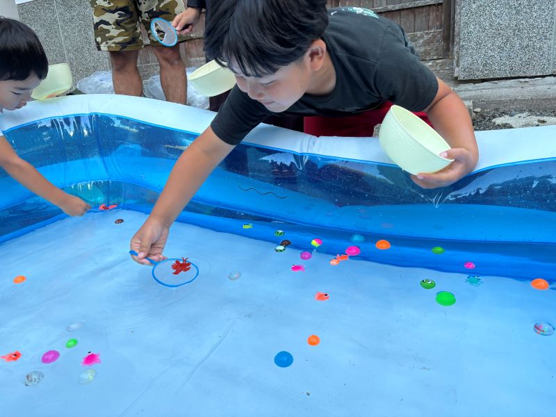 ボールすくいをする男の子