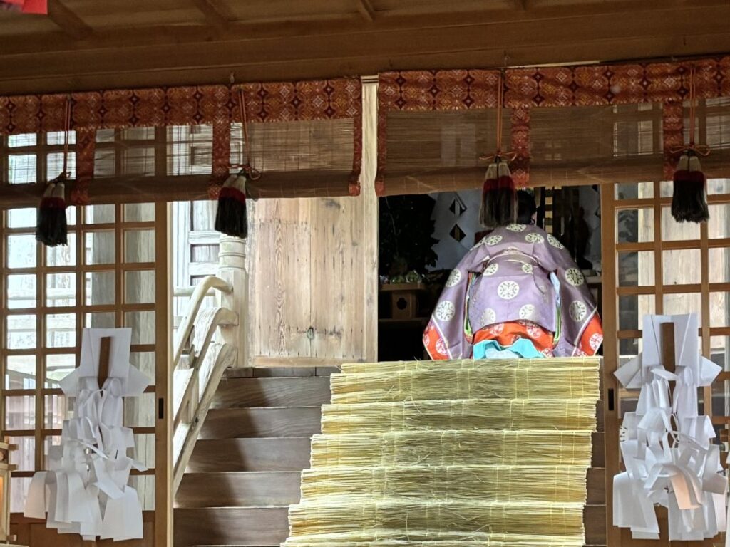 本殿で祈りをささげる女性宮司