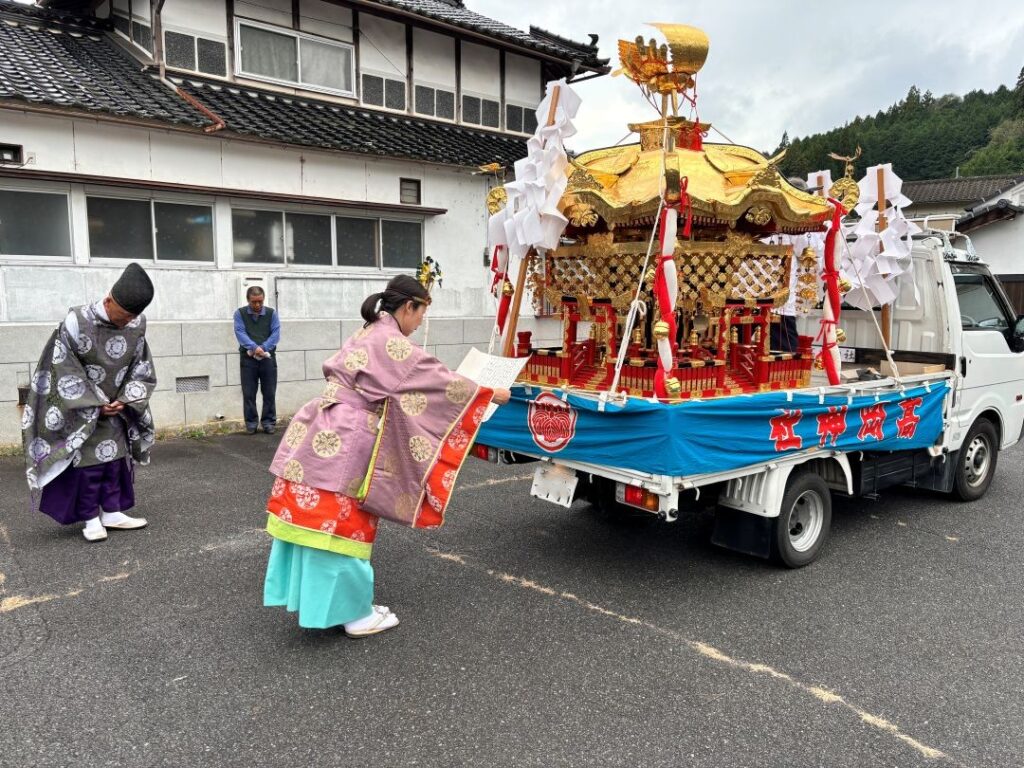 商店街の駐車場でご祈祷する女性宮司