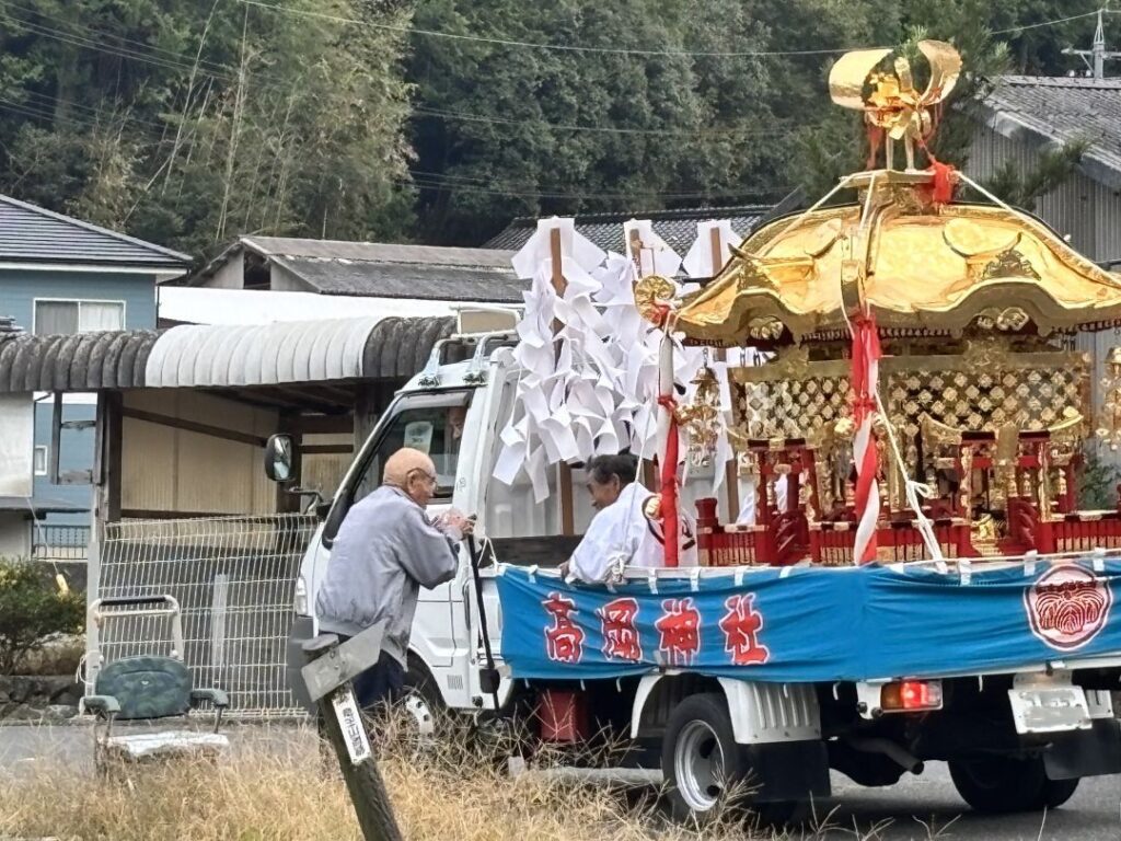 お神輿に手を合わせる近所の男性