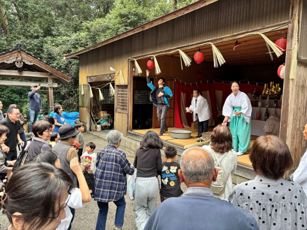 餅まきをする女性宮司